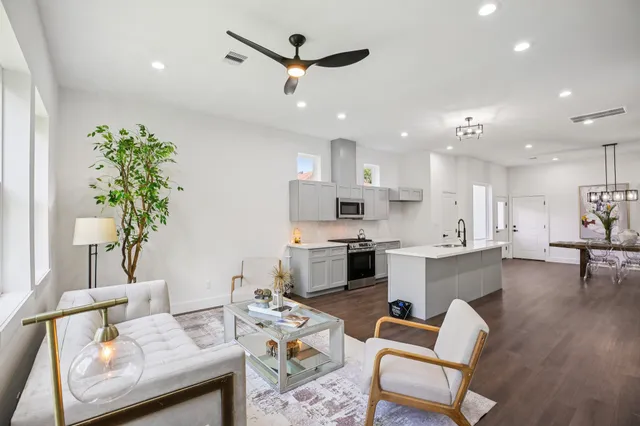 a living room with furniture kitchen and a potted plant