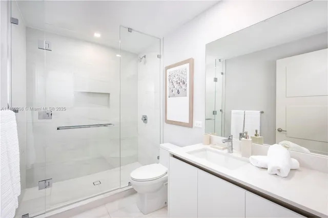 a bathroom with a granite countertop sink a toilet and shower
