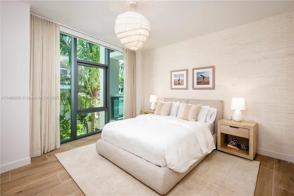 a bedroom with a large bed and a chandelier