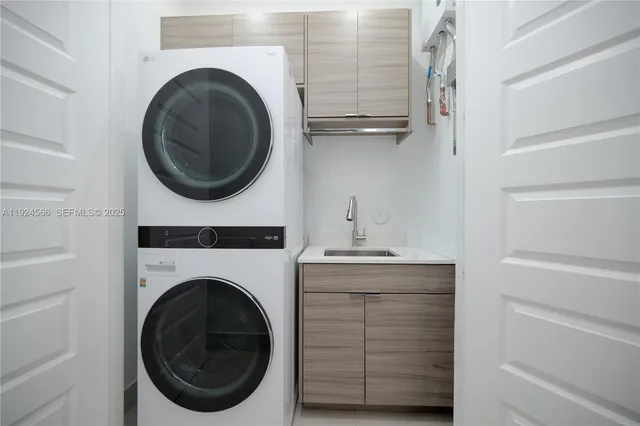 a utility room with sink dryer and washer