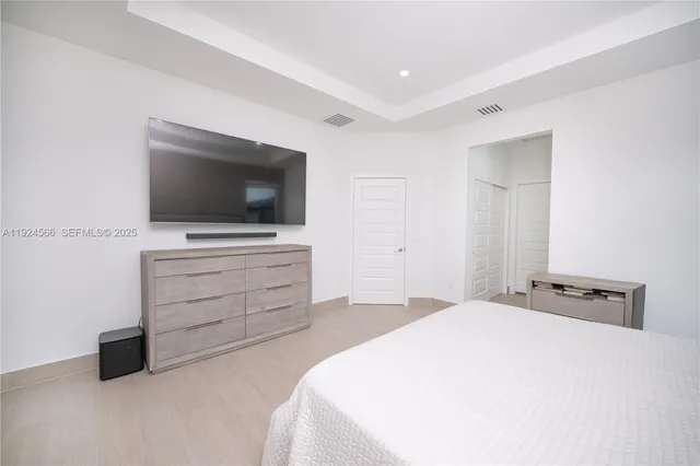 a bedroom with a bed and a flat screen tv