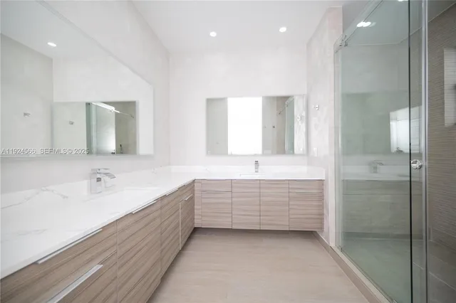 a bathroom with a double vanity sink mirror and bathtub
