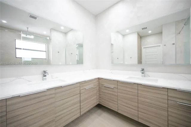 a bathroom with double sink and mirror