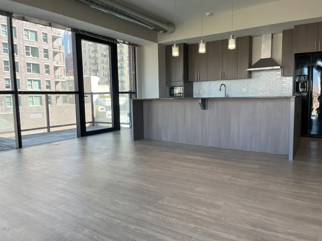 a kitchen with white cabinets and wooden floor