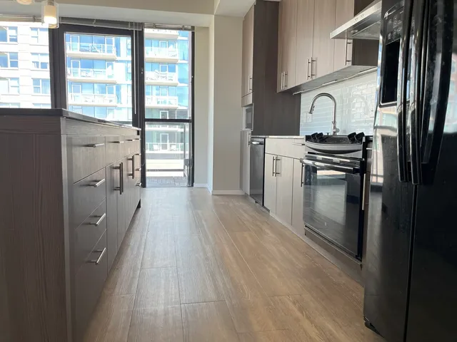 a view of an empty room with wooden floor and a floor to ceiling window