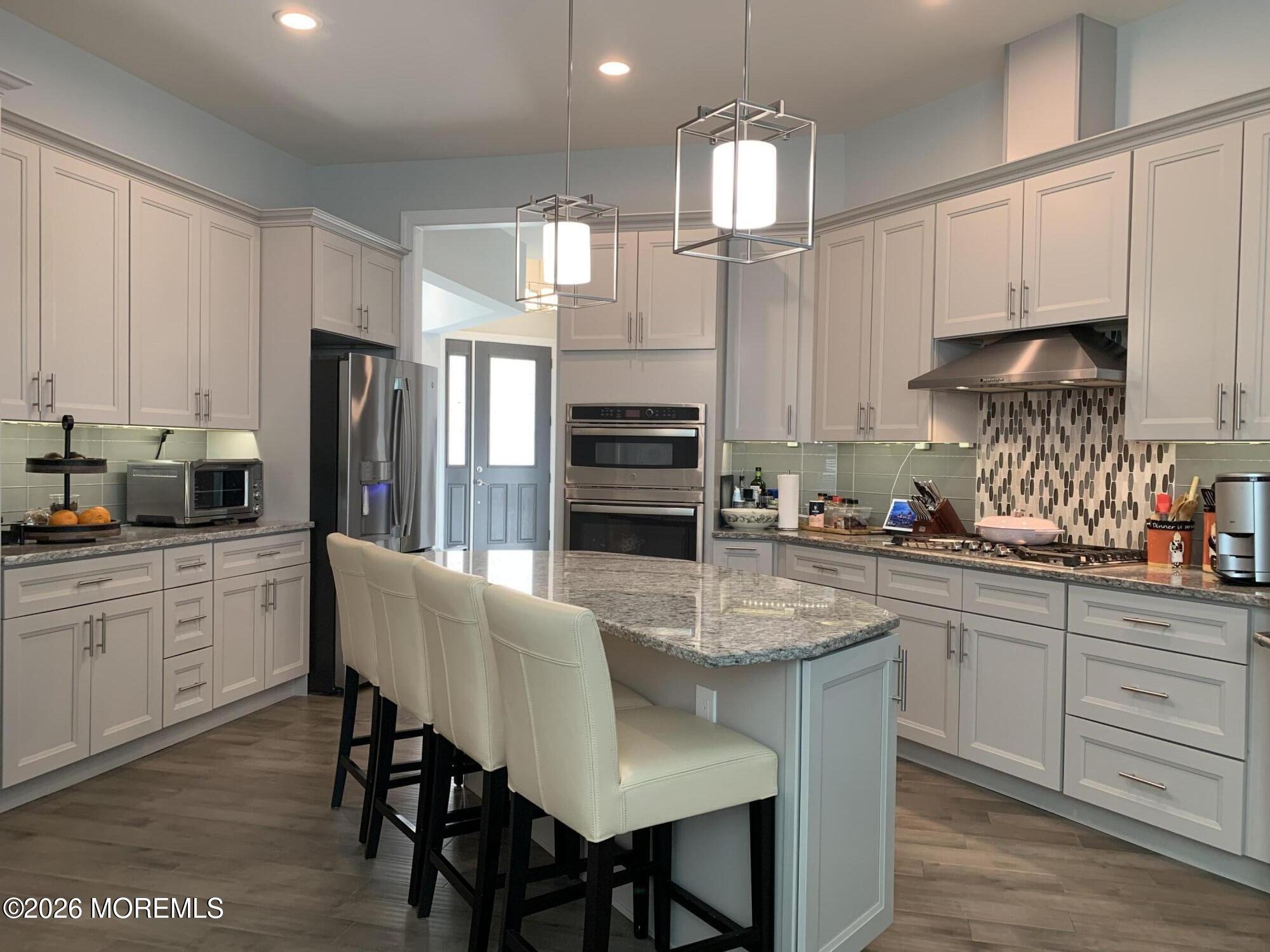 67 Samjan Circle Hightstown, NJ 08520 - Photo 4 of 22 a kitchen with stainless steel appliances granite countertop a stove refrigerator sink and cabinets