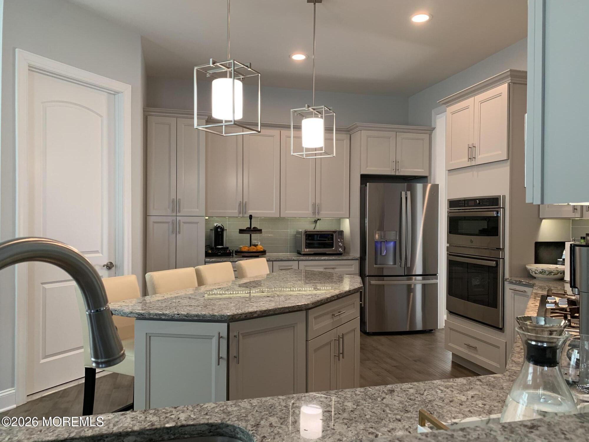 67 Samjan Circle Hightstown, NJ 08520 - Photo 5 of 22 a kitchen with kitchen island granite countertop a refrigerator a stove a sink and a refrigerator with wooden floor