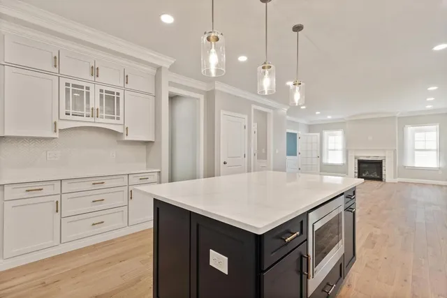 a kitchen that has a lot of cabinets in it and wooden floor