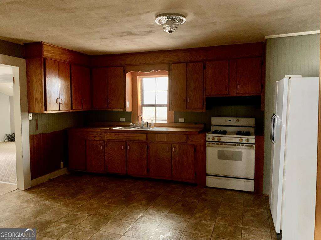 606 West 7th Street Alma, GA 31510 - Photo 14 of 28 a kitchen with sink a microwave and refrigerator