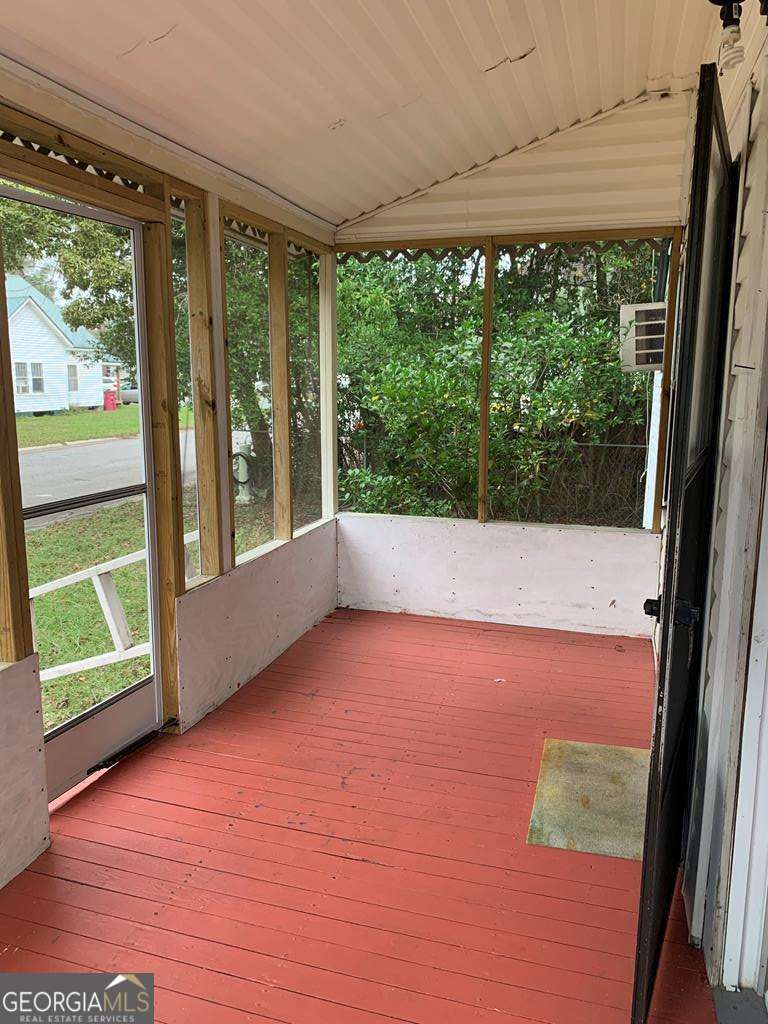 606 West 7th Street Alma, GA 31510 - Photo 5 of 28 a view of an empty room with wooden floor and doors
