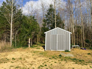 392 Scott Road Sharon Grove, KY 42280 - Photo 7 of 36 a view of a wooden house with large trees and covered area