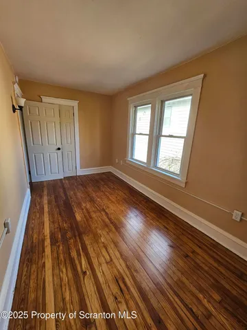 a view of a room with wooden floor and windows