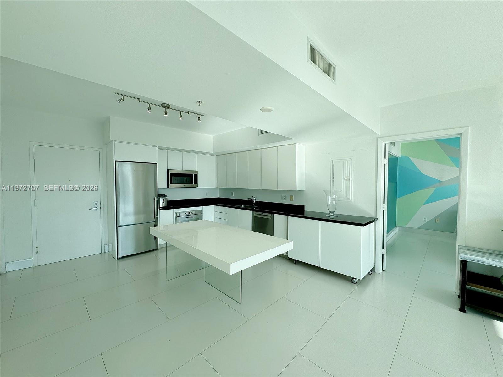 92 Southwest 3rd Street, Unit 3912 Miami, FL 33130 - Photo 11 of 33 a large white kitchen with a stove a sink and a refrigerator