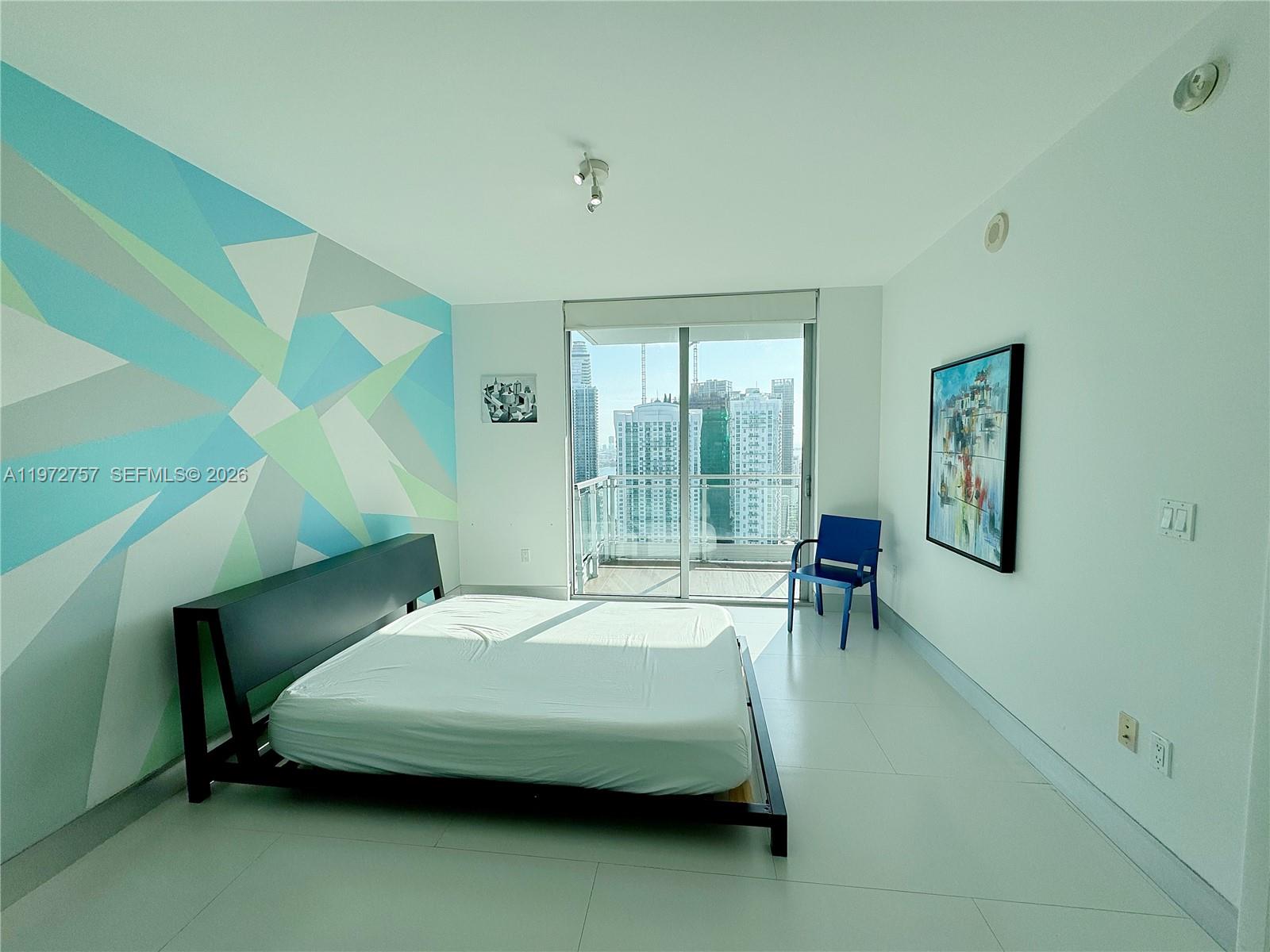 92 Southwest 3rd Street, Unit 3912 Miami, FL 33130 - Photo 13 of 33 a bedroom with a bed chair and two windows