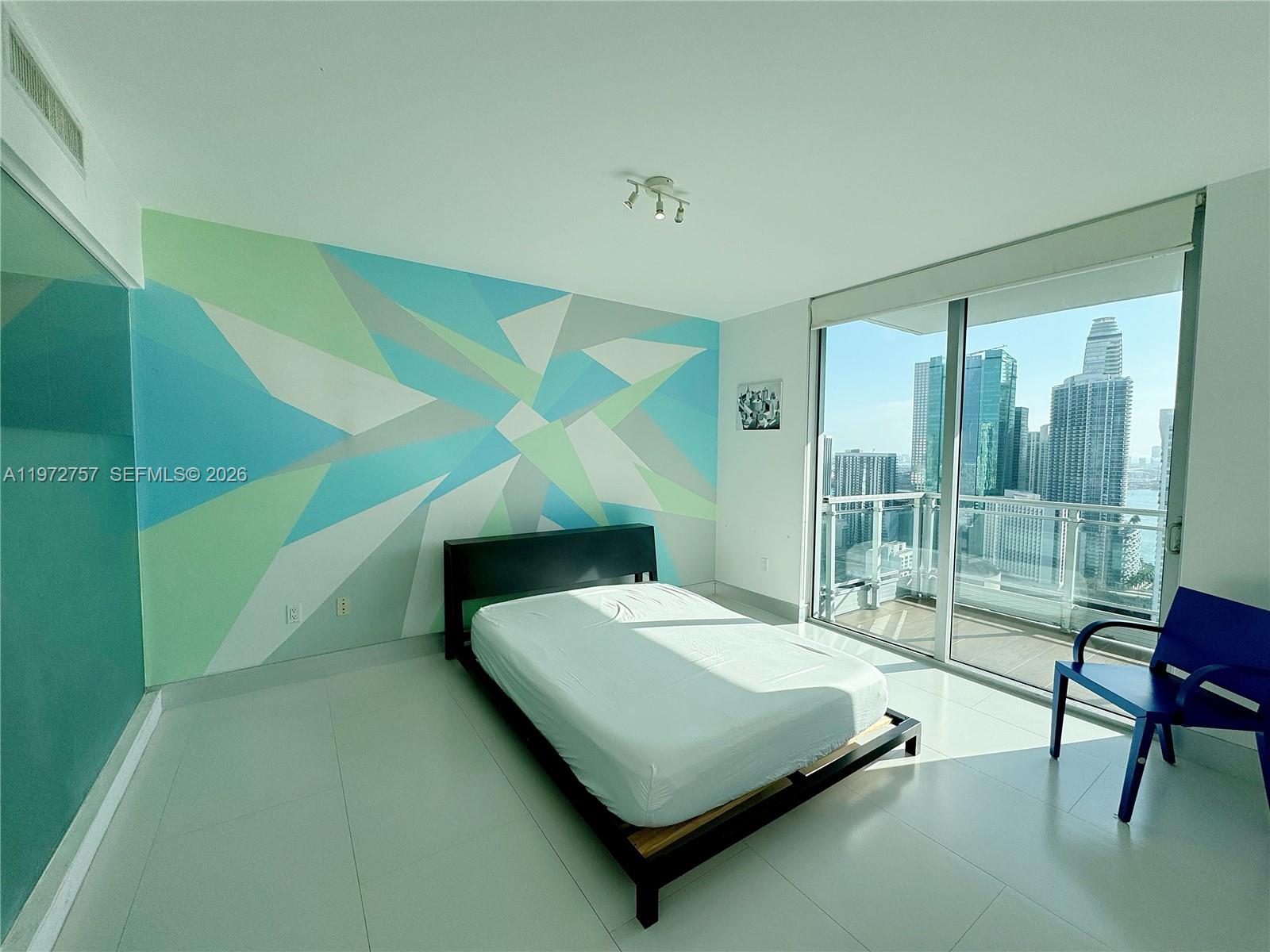 92 Southwest 3rd Street, Unit 3912 Miami, FL 33130 - Photo 15 of 33 a bedroom with a bed and a large window