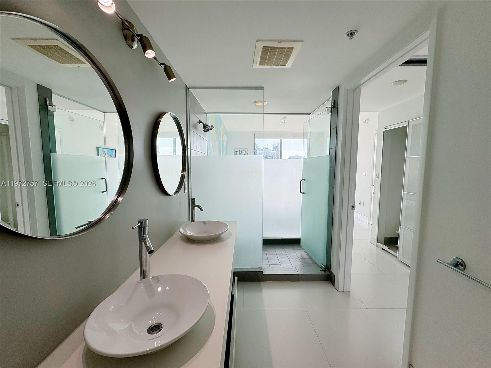 92 Southwest 3rd Street, Unit 3912 Miami, FL 33130 - Photo 17 of 33 a bathroom with a sink and a mirror