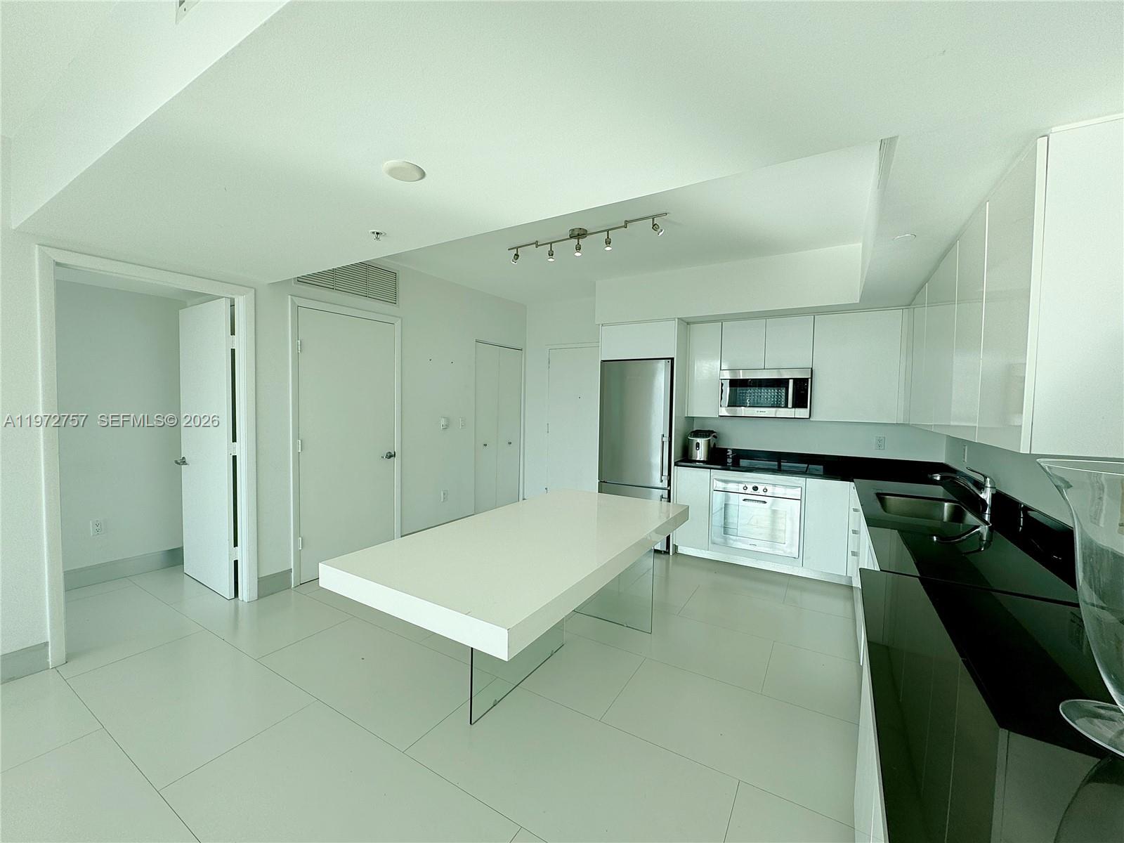 92 Southwest 3rd Street, Unit 3912 Miami, FL 33130 - Photo 10 of 33 a large kitchen with kitchen island a sink stainless steel appliances and cabinets