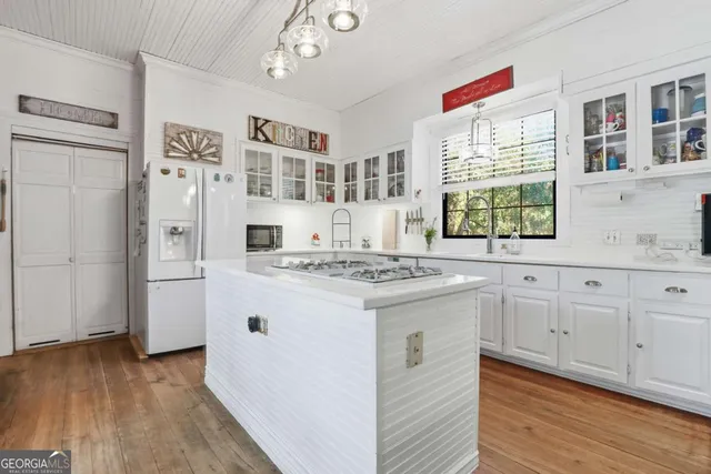 a large white kitchen with a large window