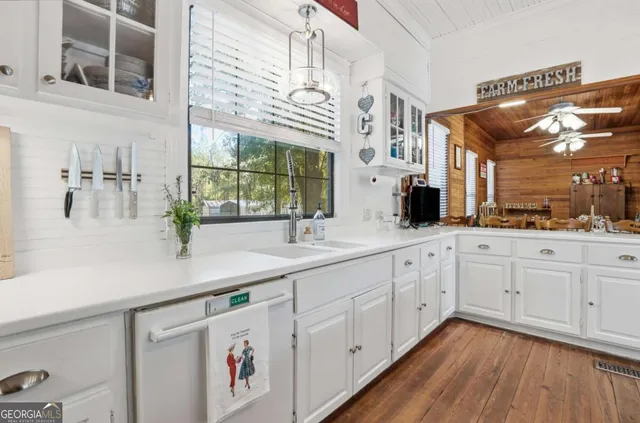 a spacious bathroom with a double vanity sink a mirror a bathtub and next to a window