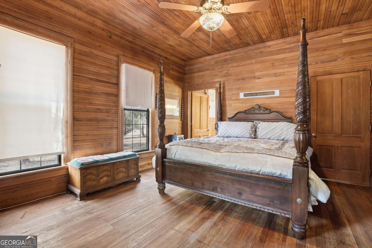 4931 Mill Branch Hunting Clb Road Pembroke, GA 31321 - Photo 21 of 71 a bedroom with a bed and wooden floor