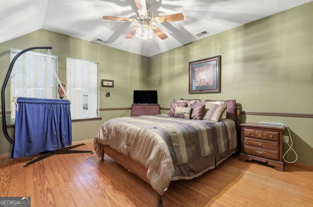 4931 Mill Branch Hunting Clb Road Pembroke, GA 31321 - Photo 30 of 71 a bedroom with a bed and a chandelier