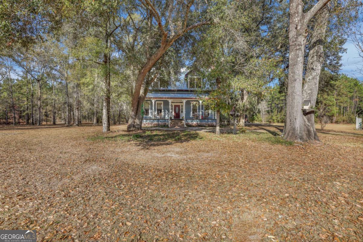 4931 Mill Branch Hunting Clb Road Pembroke, GA 31321 - Photo 63 of 71 a house with trees in front of it