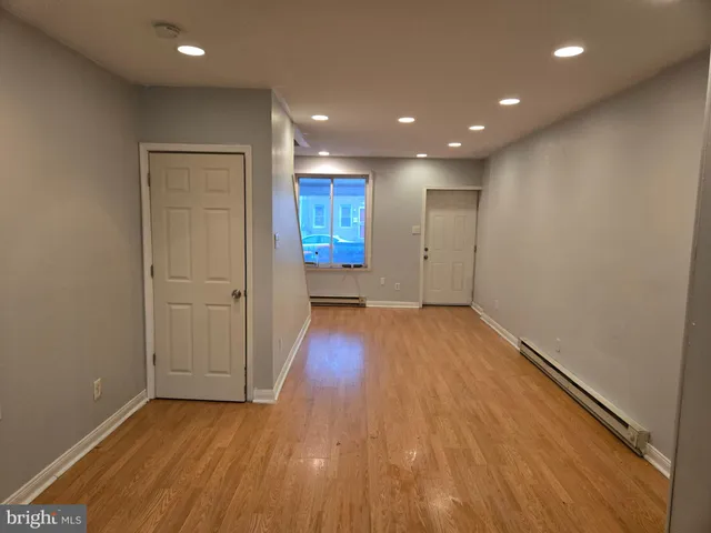 a view of empty room with wooden floor