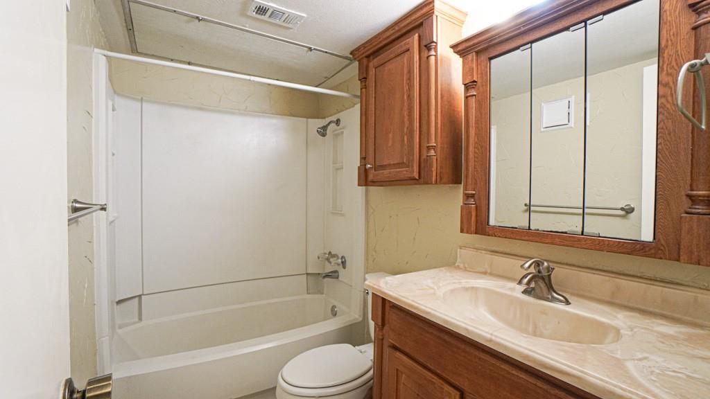 2505 Wedglea Drive, Unit 121 Dallas, TX 75211 - Photo 17 of 24 a bathroom with a granite countertop sink toilet and shower