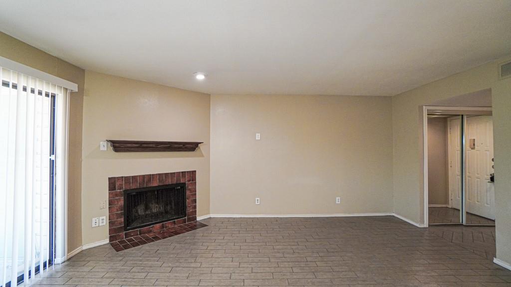 2505 Wedglea Drive, Unit 121 Dallas, TX 75211 - Photo 6 of 24 a view of an empty room with a fireplace