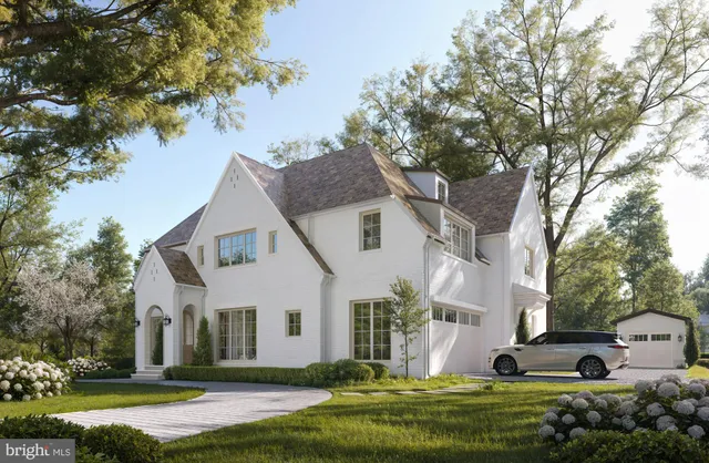 a front view of a house with a garden and trees