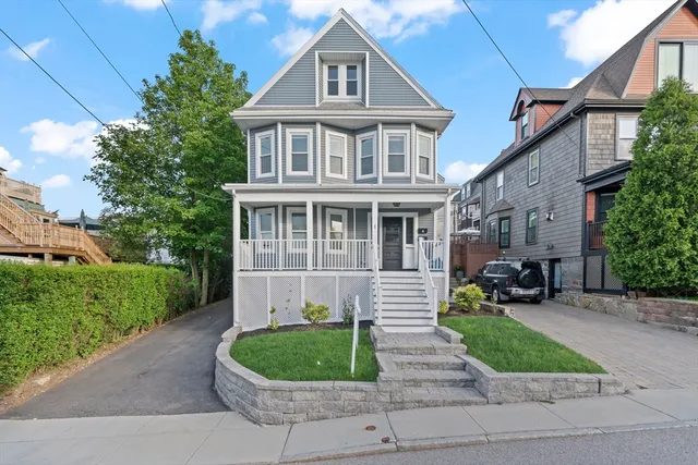 a front view of a house with a yard and trees