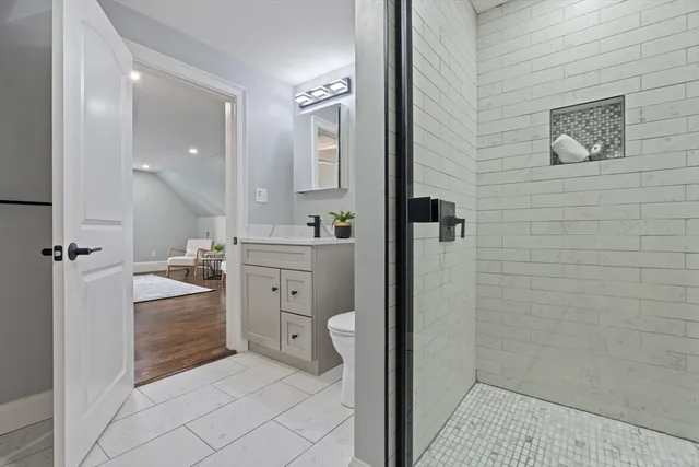 a bathroom with a sink a toilet and shower