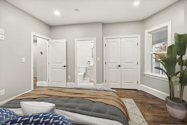 a spacious bedroom with a bed and a potted plant