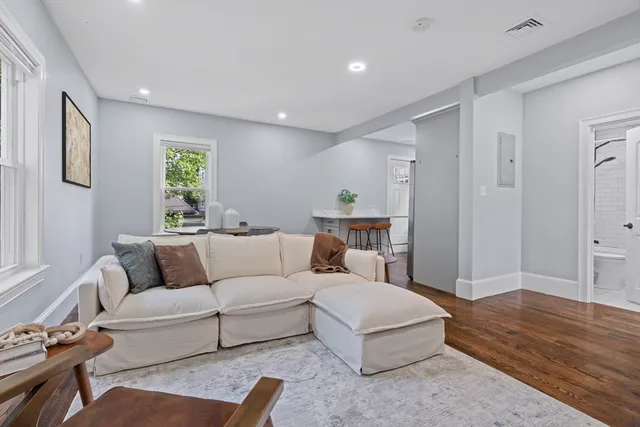 a living room with furniture and a wooden floor