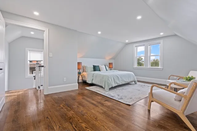 a bedroom with a bed and wooden floor