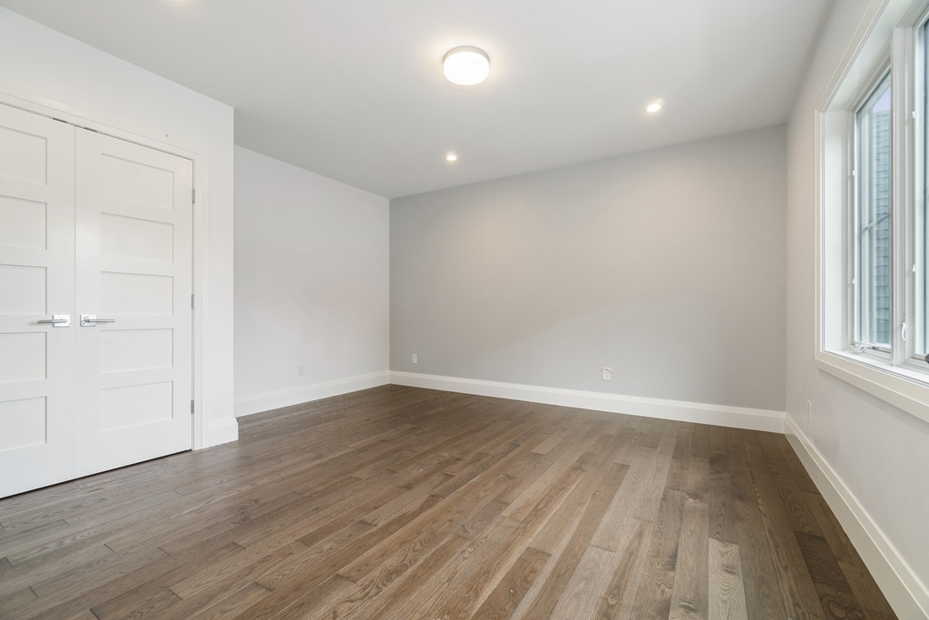 30 Coyne Road, Unit 30 Newton, MA 02468 - Photo 13 of 25 an empty room with wooden floor and windows