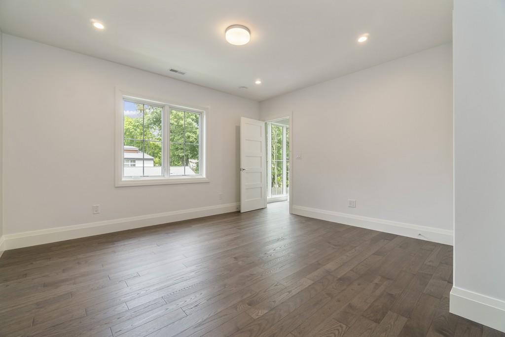 30 Coyne Road, Unit 30 Newton, MA 02468 - Photo 14 of 25 an empty room with wooden floor and windows