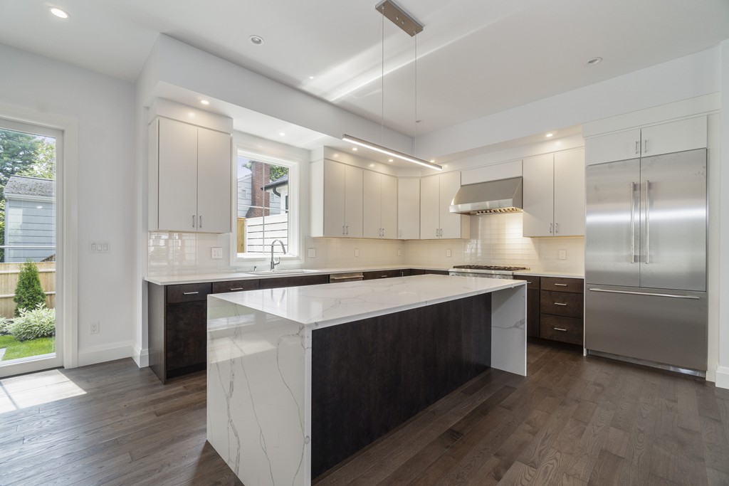30 Coyne Road, Unit 30 Newton, MA 02468 - Photo 6 of 25 a kitchen with kitchen island granite countertop a sink cabinets and stainless steel appliances