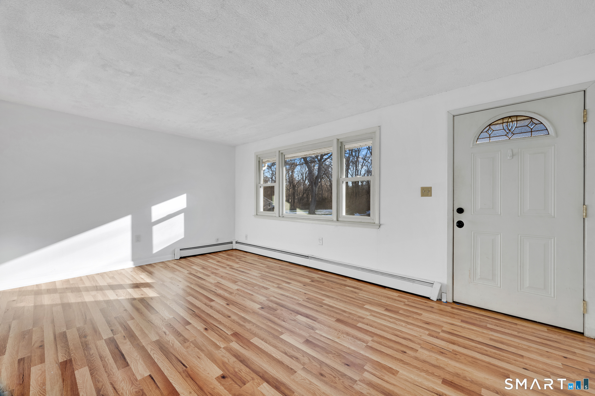 12 Nutmeg Drive Clinton, CT 06413 - Photo 3 of 26 a view of an empty room with window and wooden floor