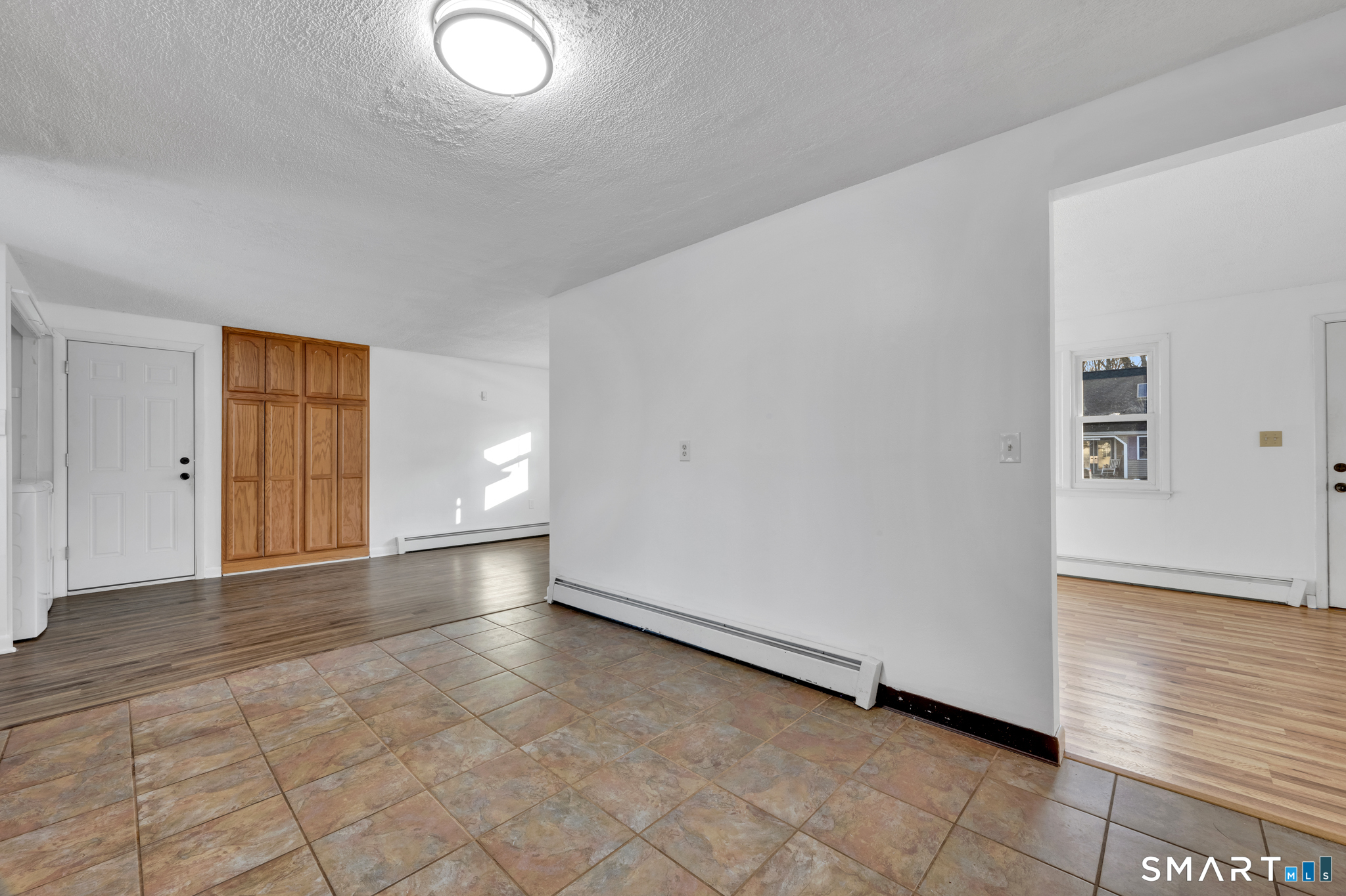 12 Nutmeg Drive Clinton, CT 06413 - Photo 7 of 26 a view of an empty room with wooden floor and a window