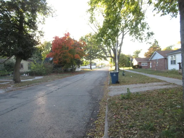 a view of a street with a building and trees