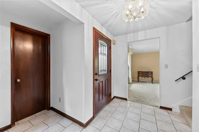 a view of a hallway with wooden floor and a chandelier