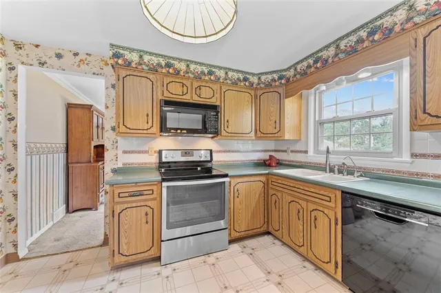 a kitchen with stainless steel appliances granite countertop a refrigerator a sink dishwasher a stove and white countertops with wooden floor