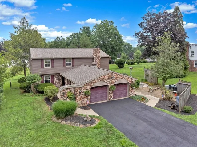 a front view of a house with a garden and yard