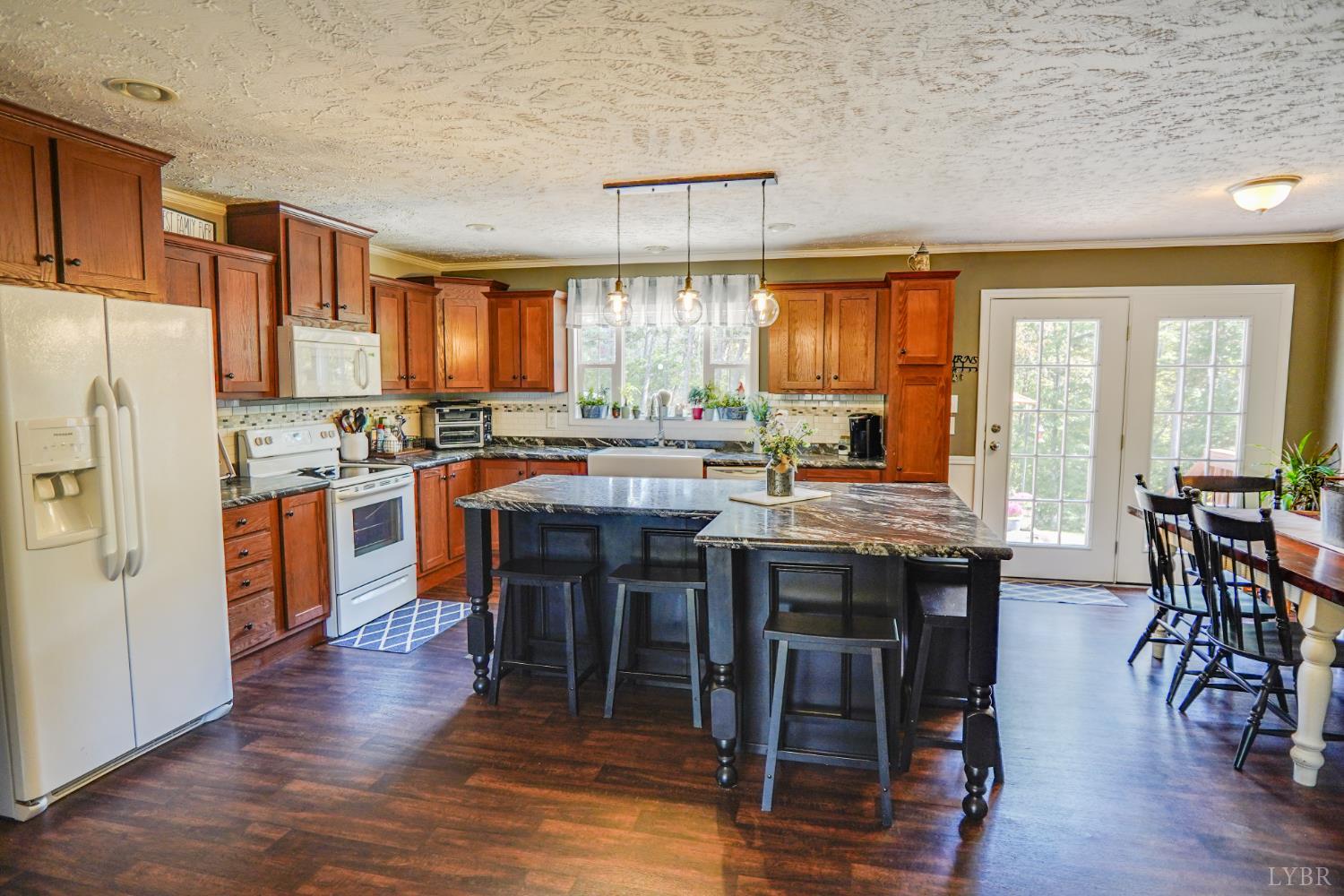 159 Hidden Trail Rustburg, VA 24588 - Photo 20 of 34 a kitchen with stainless steel appliances granite countertop wooden floor a dining table and chairs