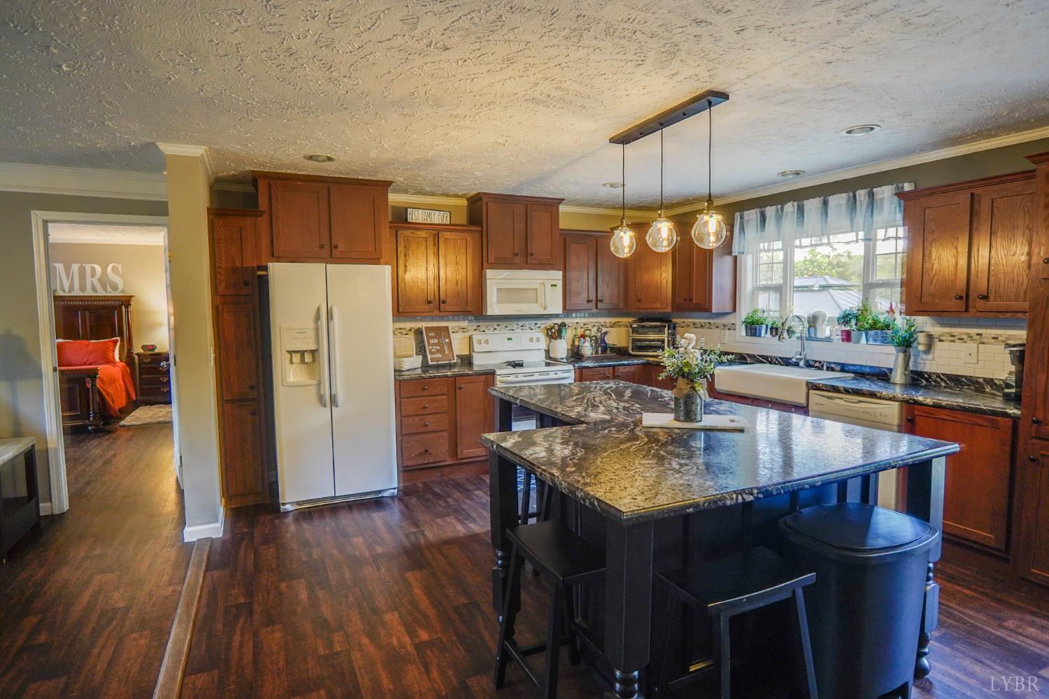 159 Hidden Trail Rustburg, VA 24588 - Photo 21 of 34 a kitchen with stainless steel appliances granite countertop a refrigerator a sink dishwasher a stove and a dining table with wooden floor