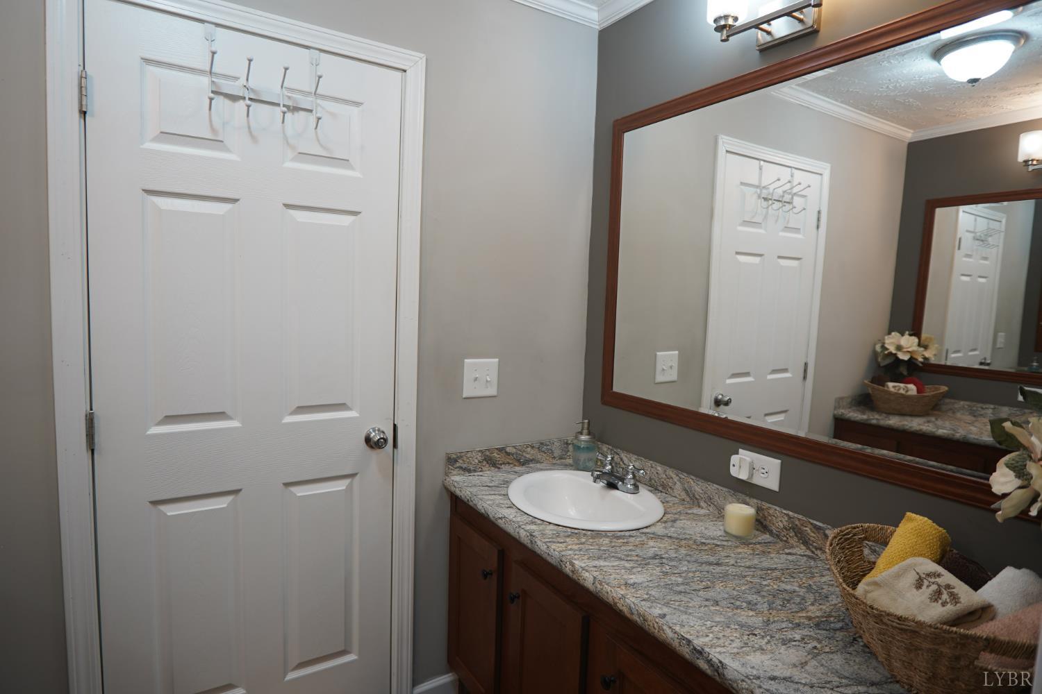 159 Hidden Trail Rustburg, VA 24588 - Photo 31 of 34 a bathroom with a granite countertop sink and a mirror