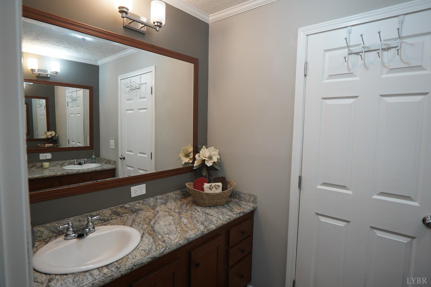 159 Hidden Trail Rustburg, VA 24588 - Photo 32 of 34 a bathroom with a granite countertop sink and a mirror