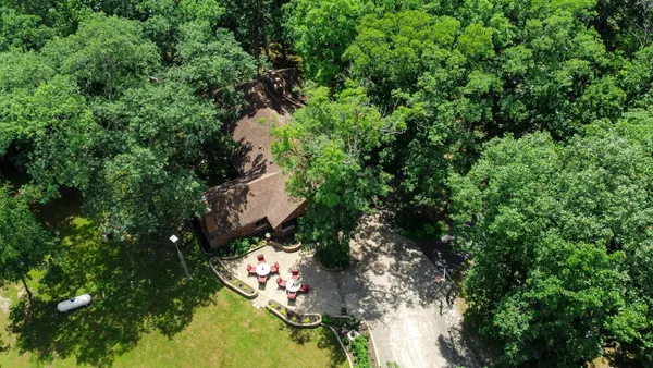 an aerial view of a residential houses with yard