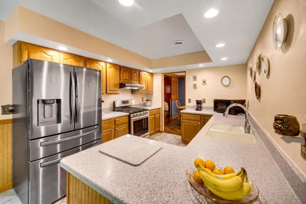 a kitchen with stainless steel appliances kitchen island granite countertop a sink and cabinets